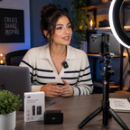 Content creator wearing wireless lavalier microphone at desk setup with ring light and phone on tripod